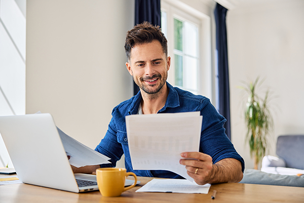 man at computer with papers