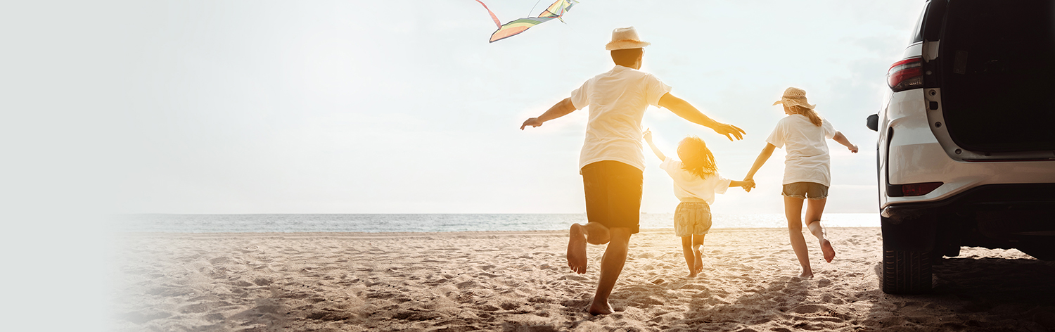 Family on beach with car